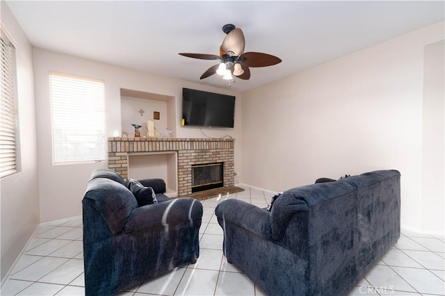 tiled living room featuring ceiling fan and a fireplace