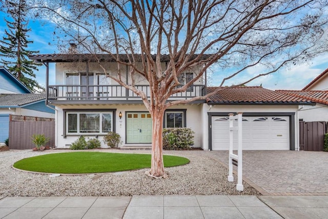 view of front of home featuring a balcony, a garage, and a front lawn