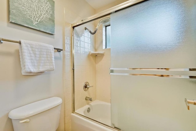 bathroom featuring enclosed tub / shower combo and toilet