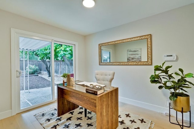 home office with light hardwood / wood-style flooring