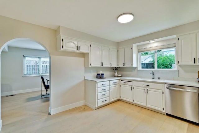 kitchen featuring sink, stainless steel dishwasher, white cabinets, and light hardwood / wood-style flooring