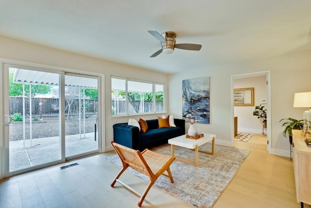 living room with ceiling fan and light hardwood / wood-style flooring