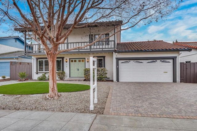 view of front of house featuring a garage, a front yard, and a balcony