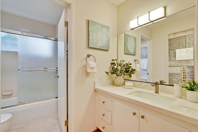 full bathroom featuring vanity, tile patterned floors, shower / bath combination with glass door, and toilet