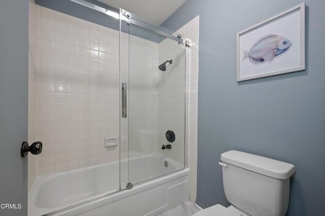 bathroom with toilet and shower / bath combination with glass door