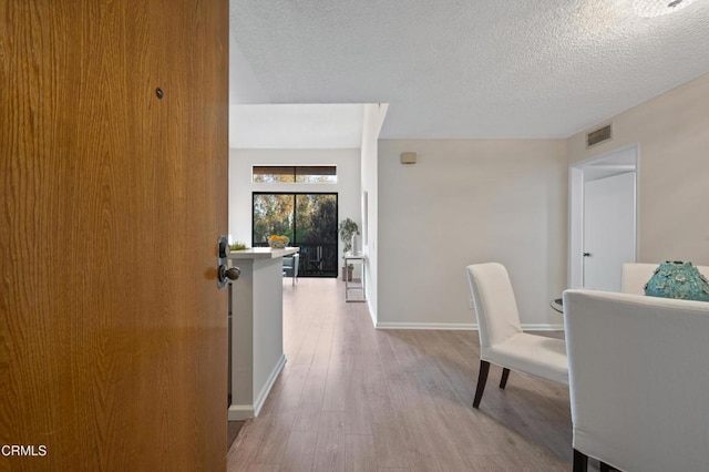 interior space featuring a textured ceiling and light wood-type flooring