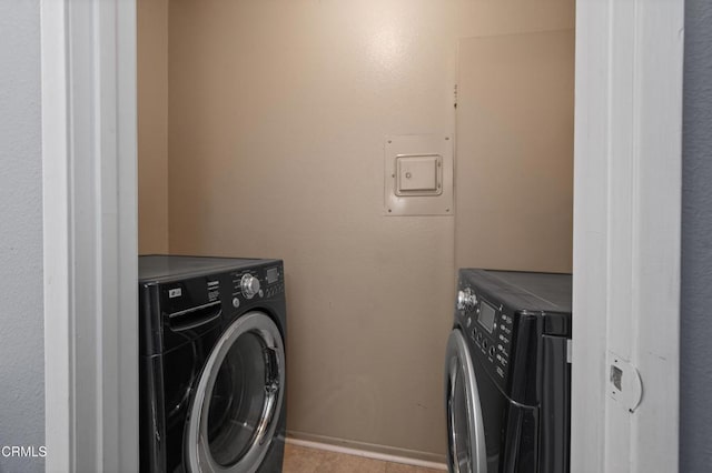 laundry area featuring washing machine and dryer and light tile patterned flooring