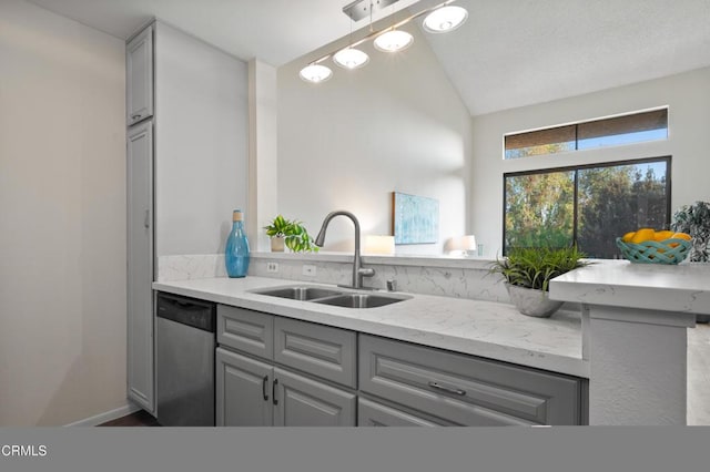 kitchen featuring lofted ceiling, dishwasher, sink, and gray cabinetry