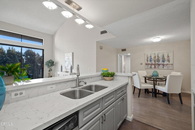 kitchen featuring sink, gray cabinetry, light stone counters, dark hardwood / wood-style floors, and pendant lighting