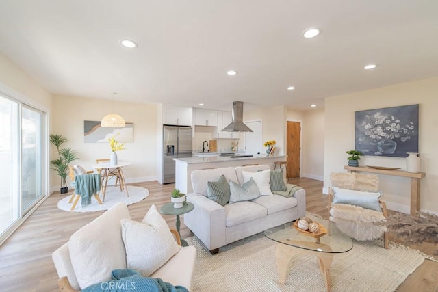 living room with sink and light hardwood / wood-style flooring