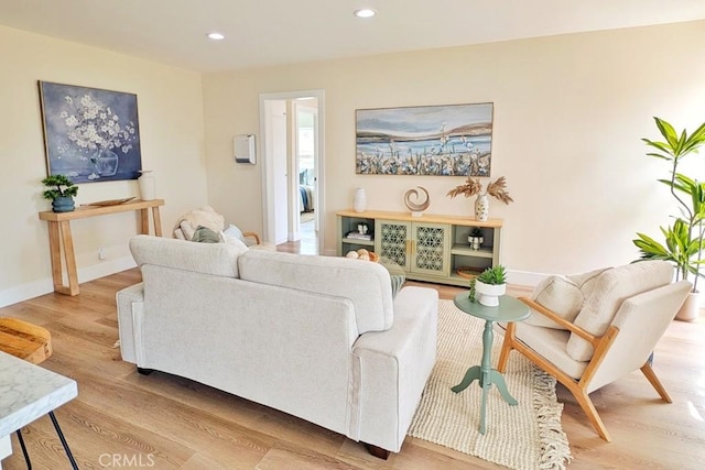 living room featuring baseboards, wood finished floors, and recessed lighting