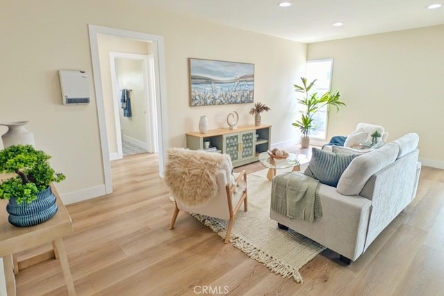 living area featuring light wood finished floors, baseboards, and recessed lighting