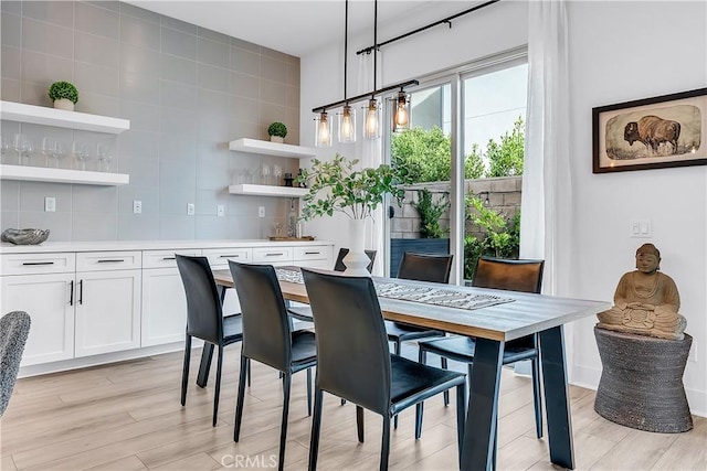 dining room featuring bar and light hardwood / wood-style floors