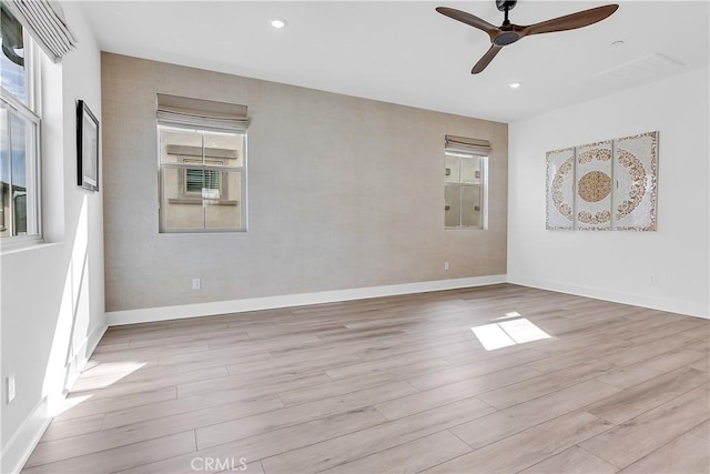 empty room with ceiling fan and light hardwood / wood-style floors