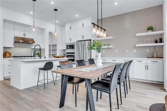 dining room featuring sink and light hardwood / wood-style floors