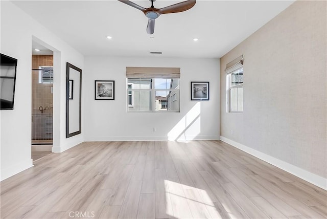 spare room with ceiling fan and light wood-type flooring