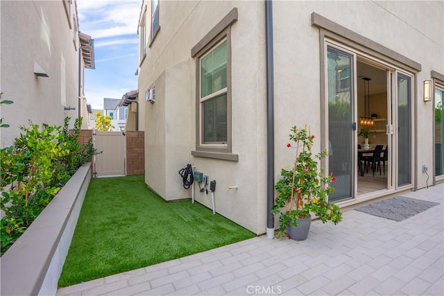 view of property exterior featuring a patio and a lawn