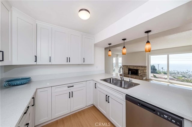 kitchen with stainless steel dishwasher, sink, and white cabinets