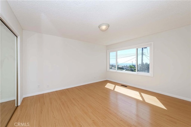 empty room featuring hardwood / wood-style floors and a textured ceiling