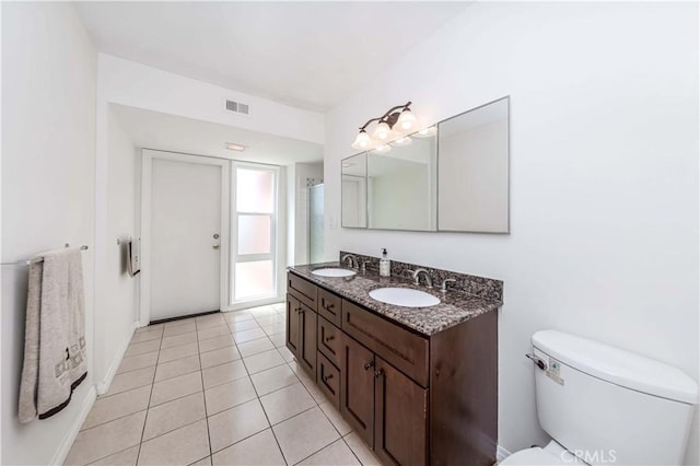 bathroom featuring vanity, tile patterned flooring, a shower, and toilet