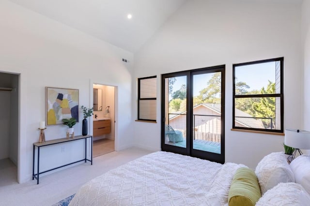 carpeted bedroom with ensuite bath, access to outside, and high vaulted ceiling