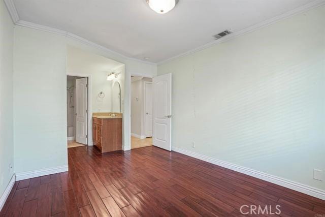 unfurnished bedroom with crown molding and dark hardwood / wood-style flooring