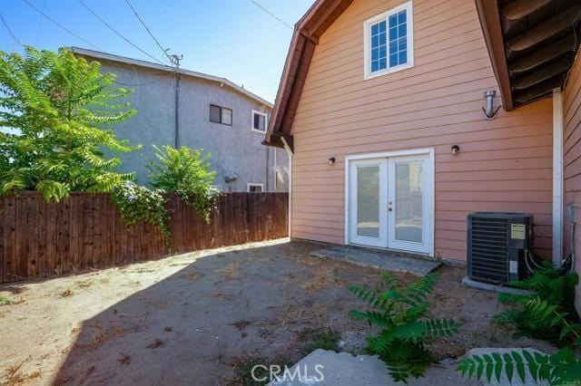 rear view of property featuring french doors and central air condition unit