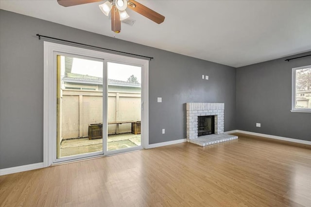 unfurnished living room featuring ceiling fan, a fireplace, and light hardwood / wood-style floors