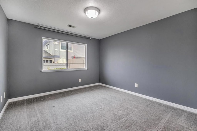 unfurnished room with carpet floors and a textured ceiling