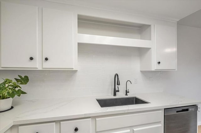 kitchen with tasteful backsplash, dishwasher, sink, white cabinets, and light stone counters