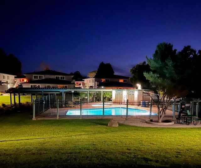 pool at twilight featuring a lawn