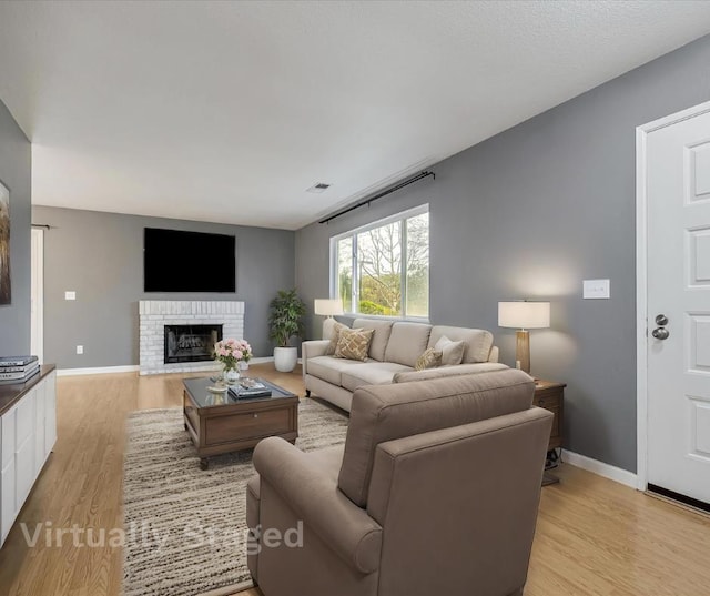 living room featuring a fireplace and light hardwood / wood-style floors