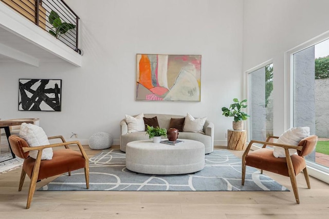 sitting room featuring a towering ceiling and hardwood / wood-style floors