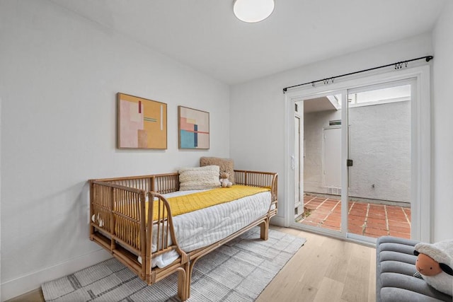 bedroom featuring access to exterior and light wood-type flooring