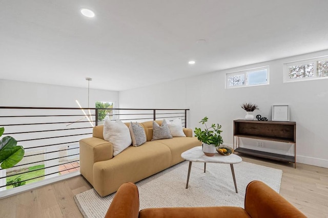 living room featuring a notable chandelier, a wealth of natural light, and light wood-type flooring