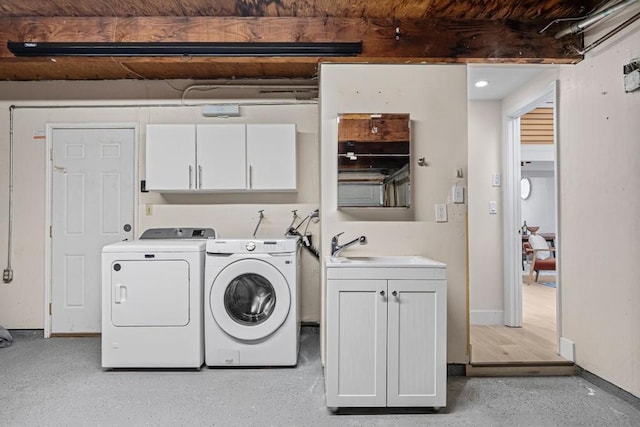 laundry area featuring sink, washing machine and dryer, and cabinets