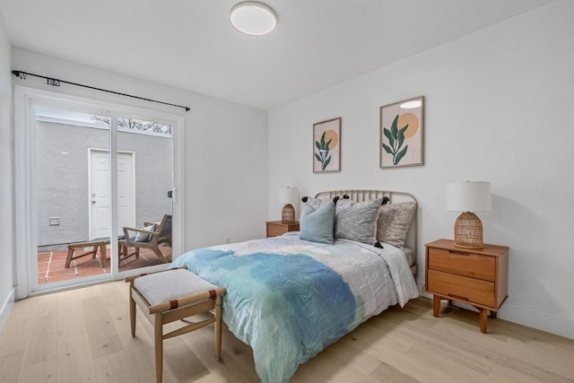 bedroom featuring access to exterior and light wood-type flooring