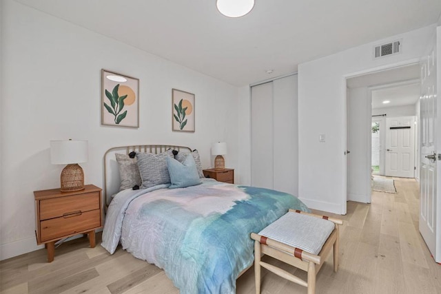 bedroom with light hardwood / wood-style floors and a closet