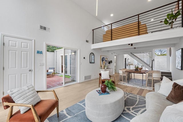 living room featuring a high ceiling and light wood-type flooring