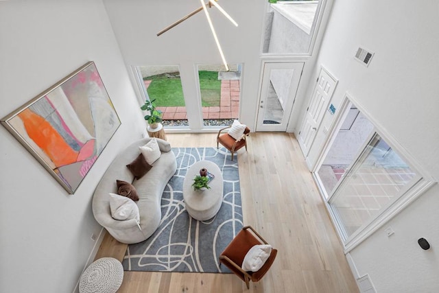 living room with wood-type flooring and a high ceiling