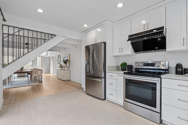 kitchen with white cabinetry, stainless steel appliances, and light hardwood / wood-style floors