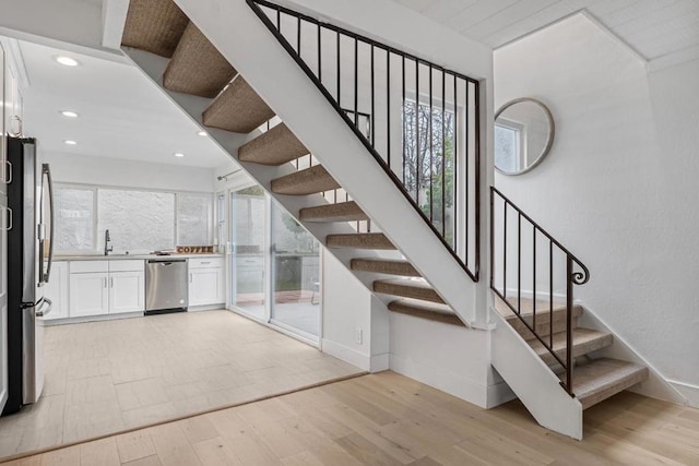 staircase featuring hardwood / wood-style flooring and sink