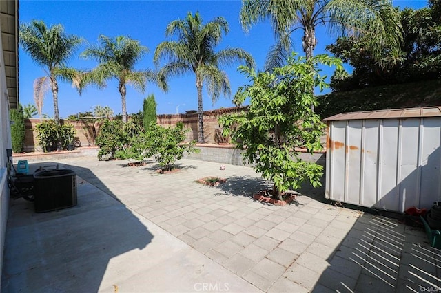 view of patio / terrace featuring central AC unit and a shed