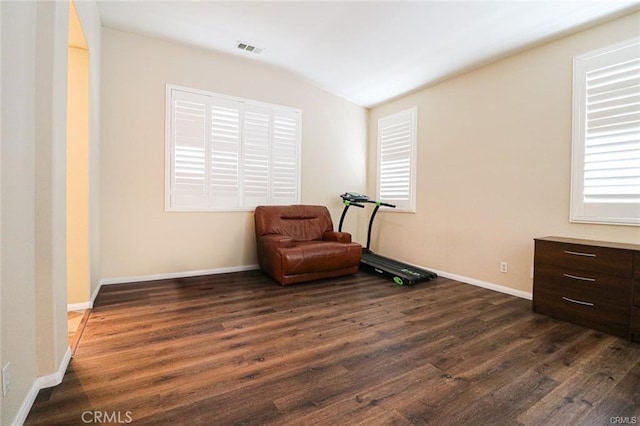 sitting room with dark wood-type flooring and vaulted ceiling