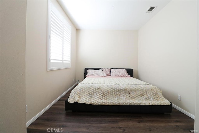 bedroom with dark hardwood / wood-style floors