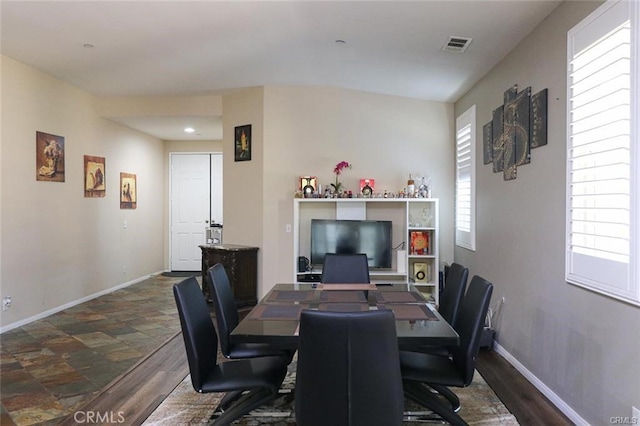 dining space with a wealth of natural light and dark hardwood / wood-style flooring