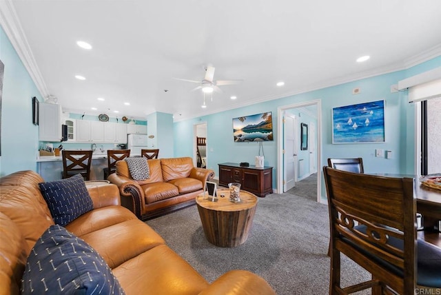 carpeted living room with ornamental molding and ceiling fan