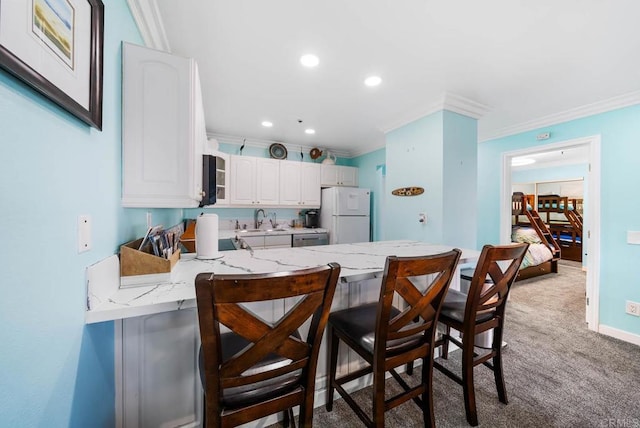 kitchen with sink, white cabinets, a kitchen breakfast bar, white fridge, and kitchen peninsula