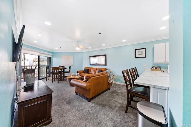 living room with ornamental molding, ceiling fan, and carpet flooring