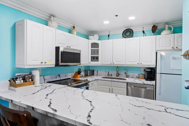 kitchen featuring sink, appliances with stainless steel finishes, light stone counters, ornamental molding, and white cabinets